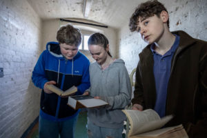 A group of visitors trying to work out a clue during The Cell Escape Room