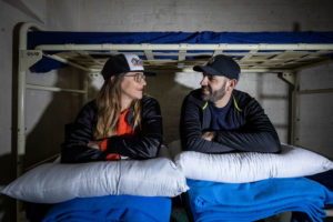 Two people sitting on a prison bed during a Night Behind Bars